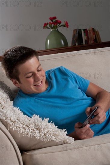 Portrait of teenage boy (16-17) with mobile phone. Photo : Rob Lewine