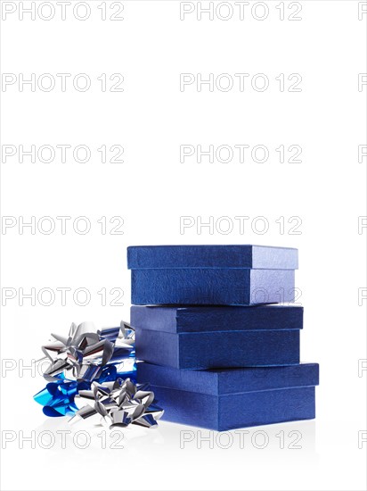 Stack of blue boxes with ribbons, studio shot. Photo : David Arky