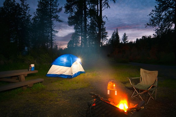 USA, Oregon, Ochoco Mountains, Tent and campfire at dusk. Photo: Gary J Weathers