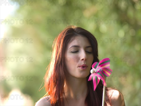 Young woman holding pinwheel. Photo : db2stock