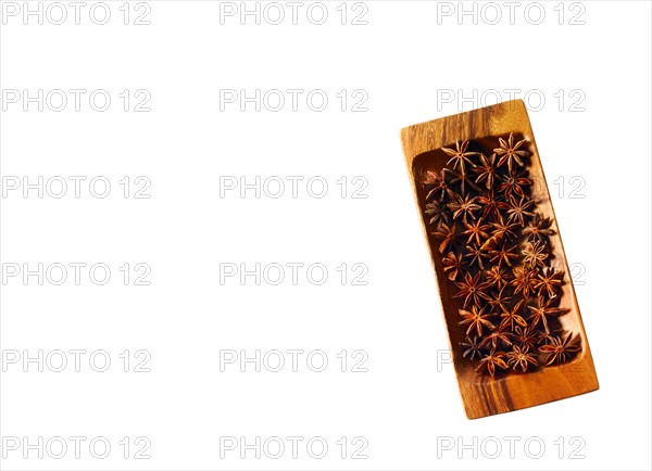 Studio shot of star anise on wooden tray. Photo : David Arky