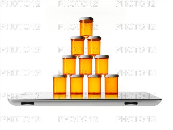 Studio shot of stack of pill bottles on digital tablet. Photo: David Arky