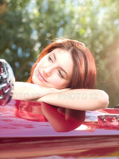 Smiling young woman in convertible car. Photo : db2stock