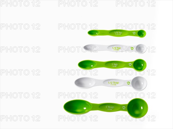 Studio shot of row of green measuring spoons. Photo : David Arky