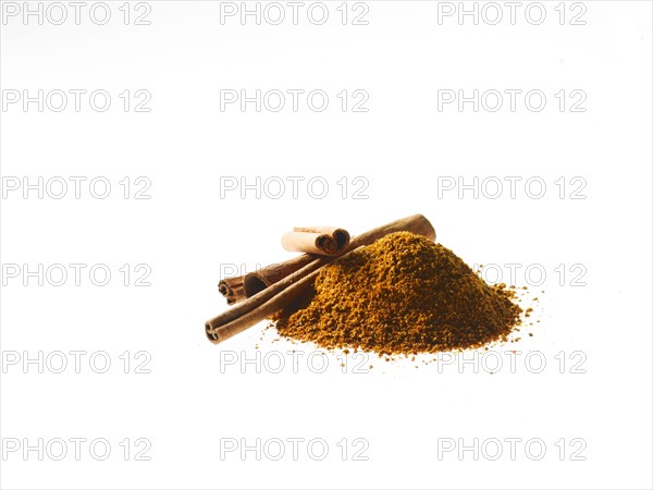 Studio shot of Ground Cinnamon and Cinnamon Sticks on white background. Photo : David Arky