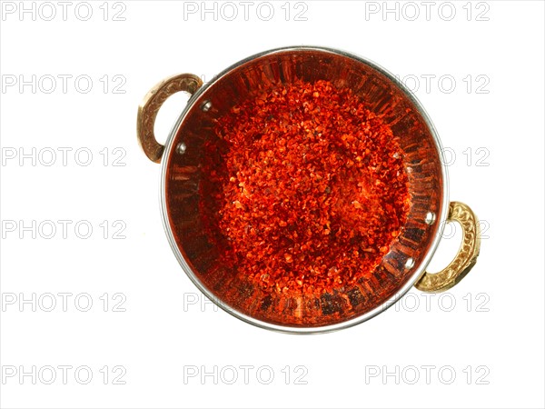 Studio shot of Red Chili Flakes in pan on white background. Photo: David Arky