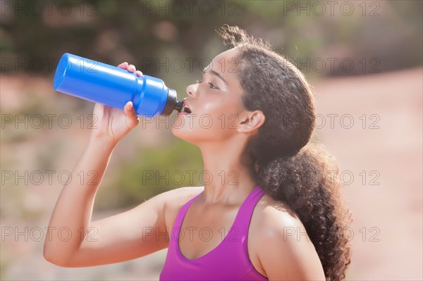 Woman drinking water after jogging. Photo : db2stock