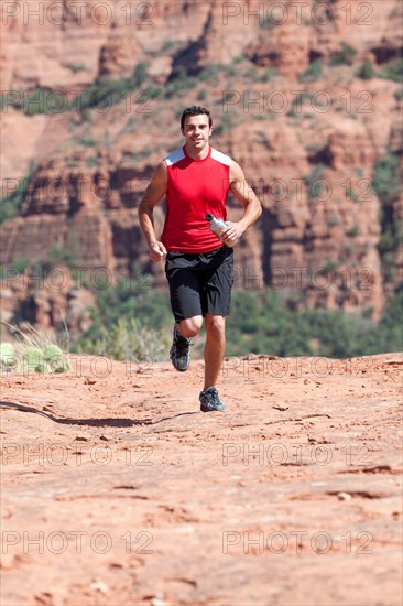 USA, Arizona, Sedona, Young man running in desert. Photo : db2stock