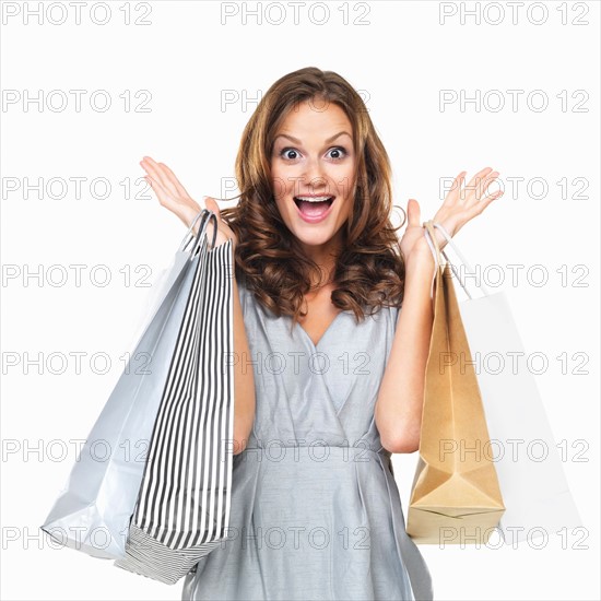 Studio portrait of happy woman holding shopping bags. Photo : momentimages