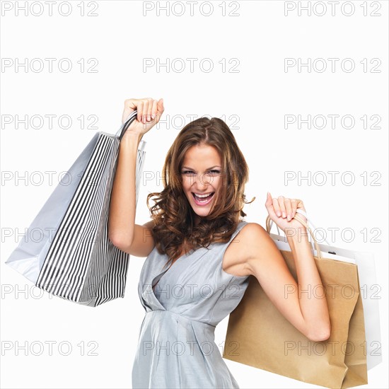 Studio portrait of happy woman holding shopping bags. Photo : momentimages