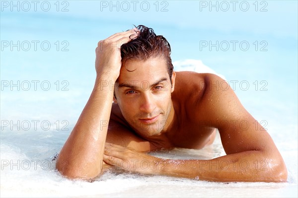 Portrait of attractive young man relaxing on beach. Photo: momentimages