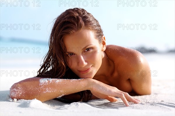 Portrait of attractive young woman relaxing on beach. Photo : momentimages