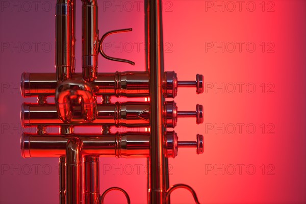 Close up of trumpet on red background. Photo : Daniel Grill