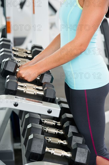 Woman in gym lifting weights.