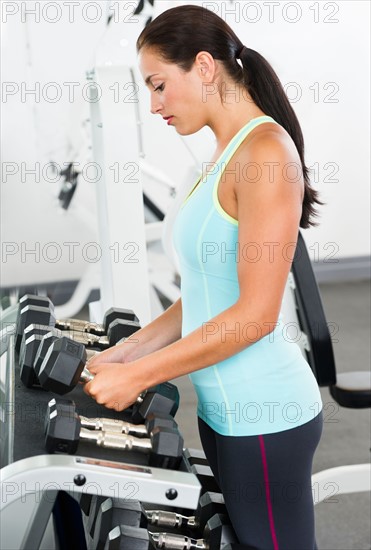 Woman in gym lifting weights.