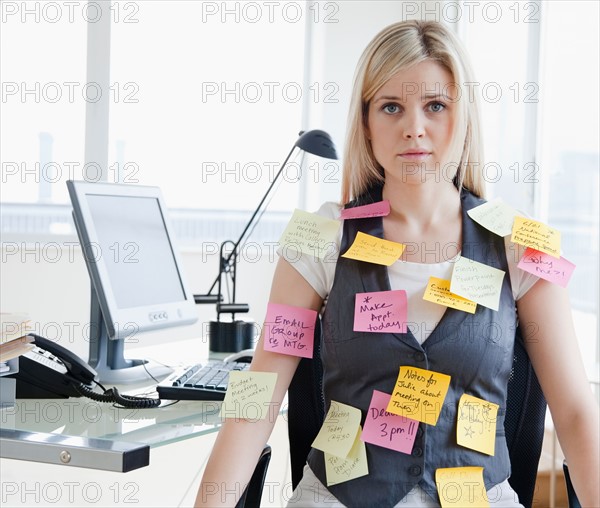 Businesswoman with memo notes on clothes. Photo : Jamie Grill