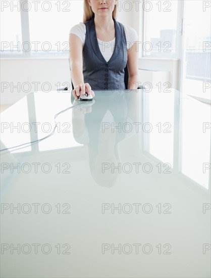 Businesswoman using computer mouse. Photo: Jamie Grill