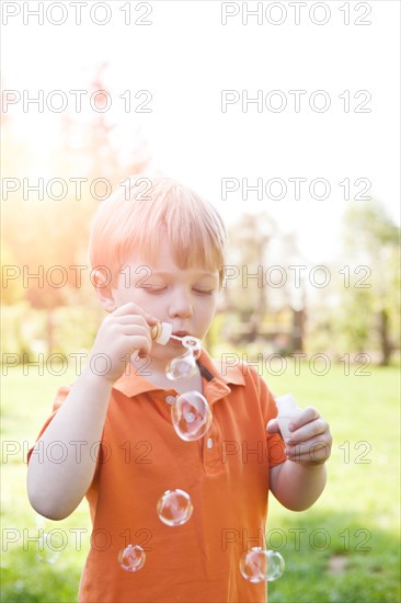 Boy (2-3) blowing bubbles in park. Photo: Take A Pix Media