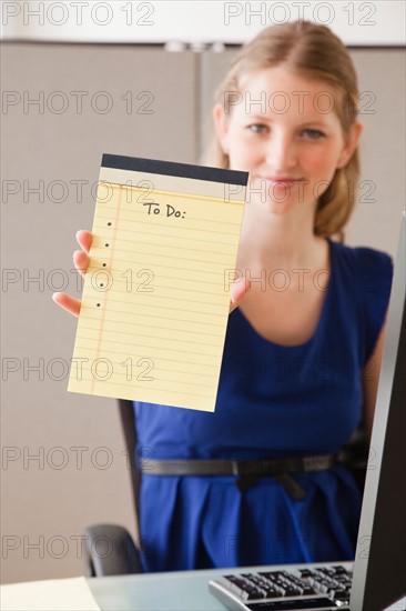 Portrait of young woman in office with blank list. Photo: Jamie Grill