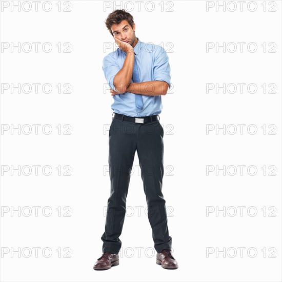 Full length of bored business man standing with hand on face against white background. Photo : momentimages