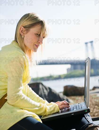 USA, Brooklyn, Williamsburg, Woman using laptop. Photo: Jamie Grill