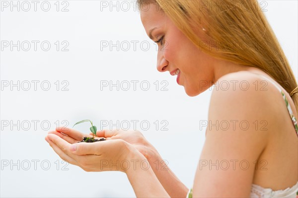 Woman holding seedling.