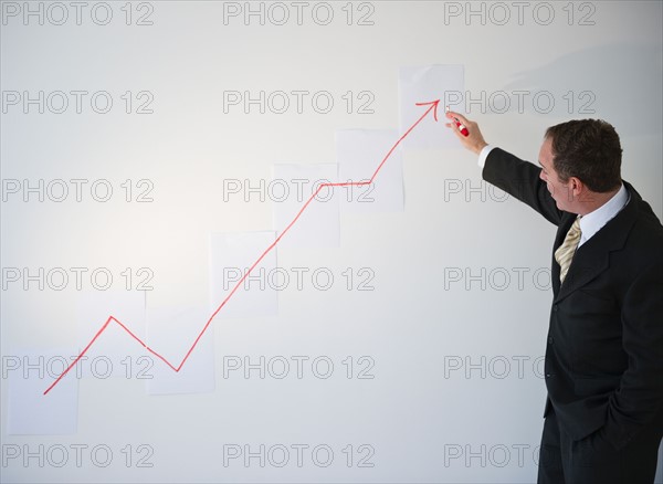 Businessman drawing chart. Photo : Jamie Grill