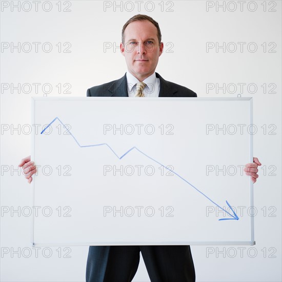 Businessman holding chart. Photo : Jamie Grill