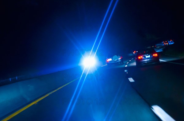 Car headlights on road at night.