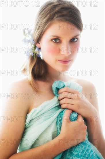 Studio portrait of young woman holding towel.