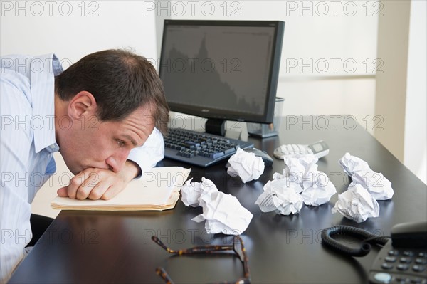 Businessman with face down on desk.
