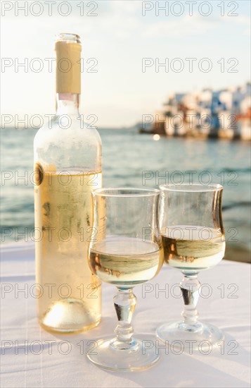 Greece, Cyclades Islands, Mykonos, Wine on table by sea.