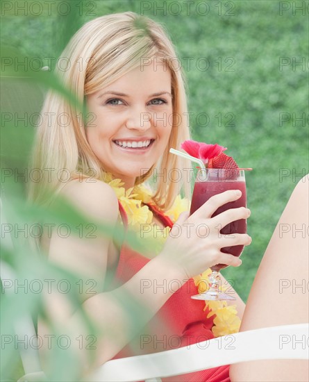 Portrait of young woman drinking cocktail. Photo : Jamie Grill