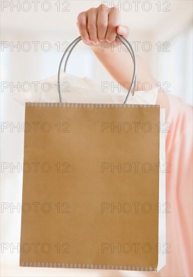 Close up of woman's hand holding shopping bag. Photo : Jamie Grill
