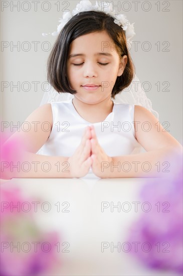 Portrait of girl (8-9) praying during Fist Communion. Photo: Jamie Grill