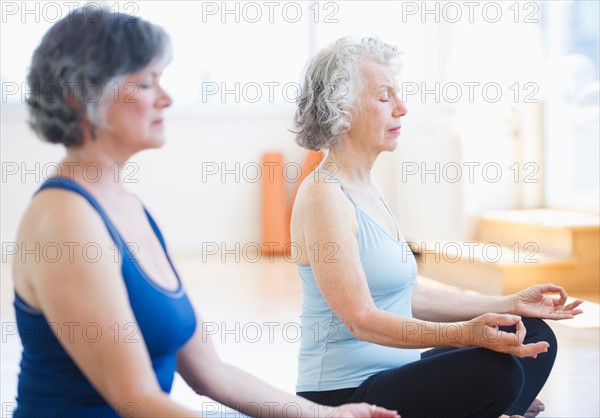 Two senior women practicing yoga. Photo : Daniel Grill