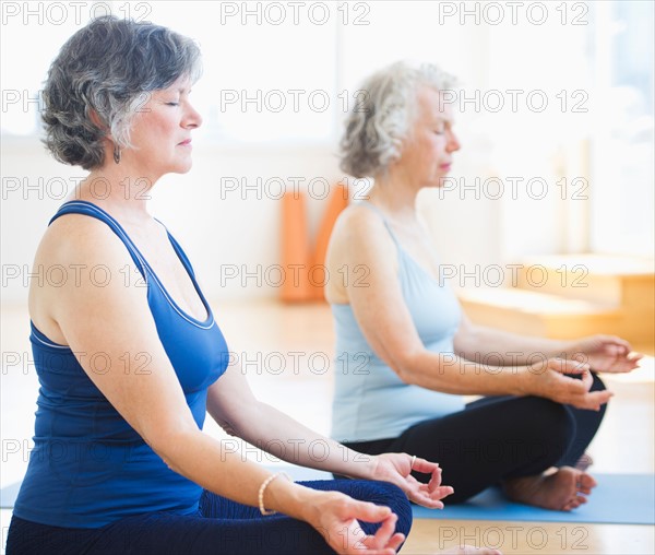 Two senior women practicing yoga. Photo : Daniel Grill