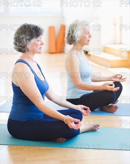 Two senior women practicing yoga. Photo : Daniel Grill