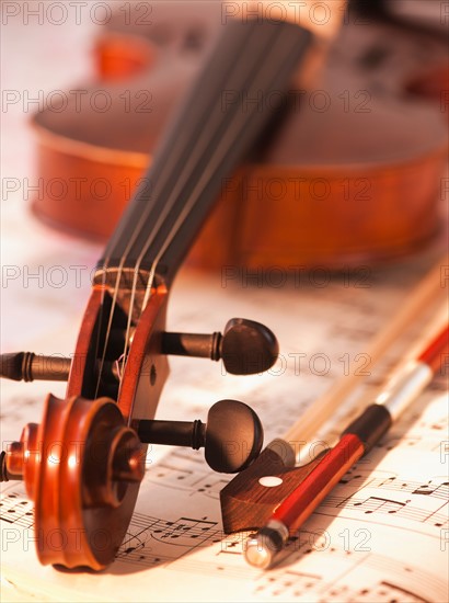 Close up of violin scroll and bow on sheet music. Photo: Daniel Grill