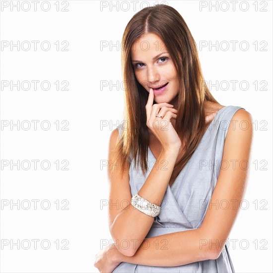 Studio portrait of young elegant woman with finger on lips. Photo : momentimages