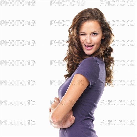 Studio portrait of young woman winking. Photo: momentimages