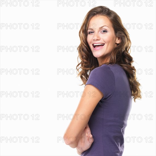 Studio portrait of beautiful young woman with hands folded and smiling. Photo : momentimages