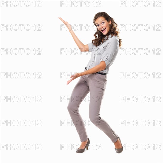 Studio shot of young smiling woman presenting copyspace. Photo : momentimages