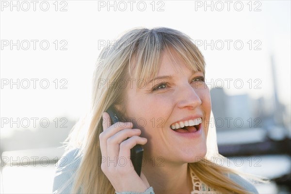 USA, Brooklyn, Williamsburg, Portrait of blonde woman talking on mobile phone. Photo : Jamie Grill