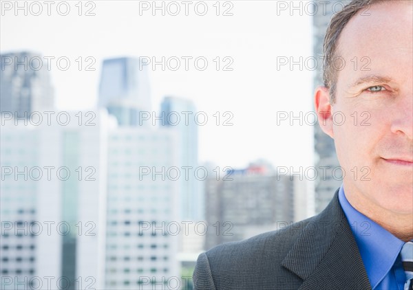 USA, New Jersey, Jersey City, Portrait of businessman against cityscape. Photo : Jamie Grill