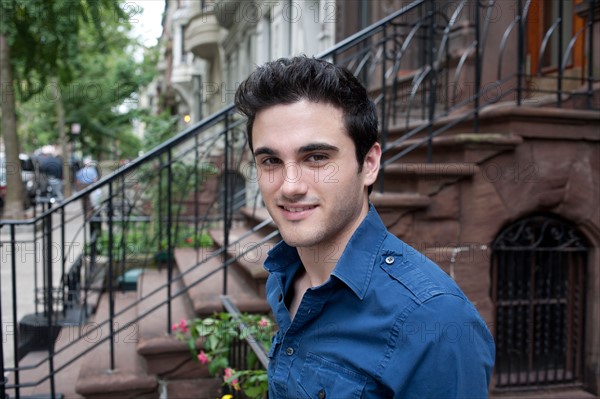 USA, New York, New York City, Portrait of smiling young man on street. Photo : Winslow Productions