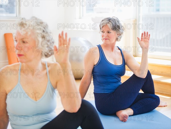 Two senior women practicing yoga. Photo : Daniel Grill