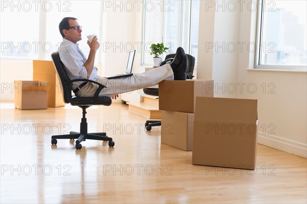 Businessman using laptop in new office.