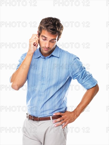 Studio shot of thoughtful business man holding his earlobe. Photo : momentimages