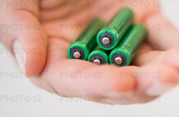 Hand holding batteries.